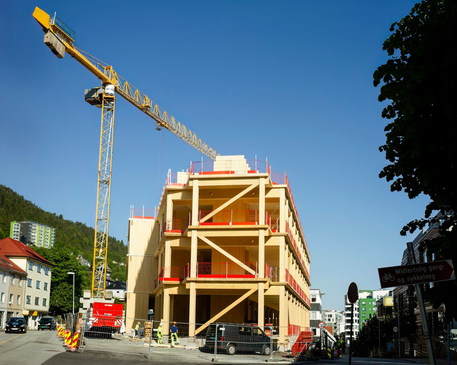 Cantiere di un edificio multipiano in legno a Bergen, in Norvegia: pilastri e controventi in lamellare, pannelli in legno massiccio e la gru di cantiere