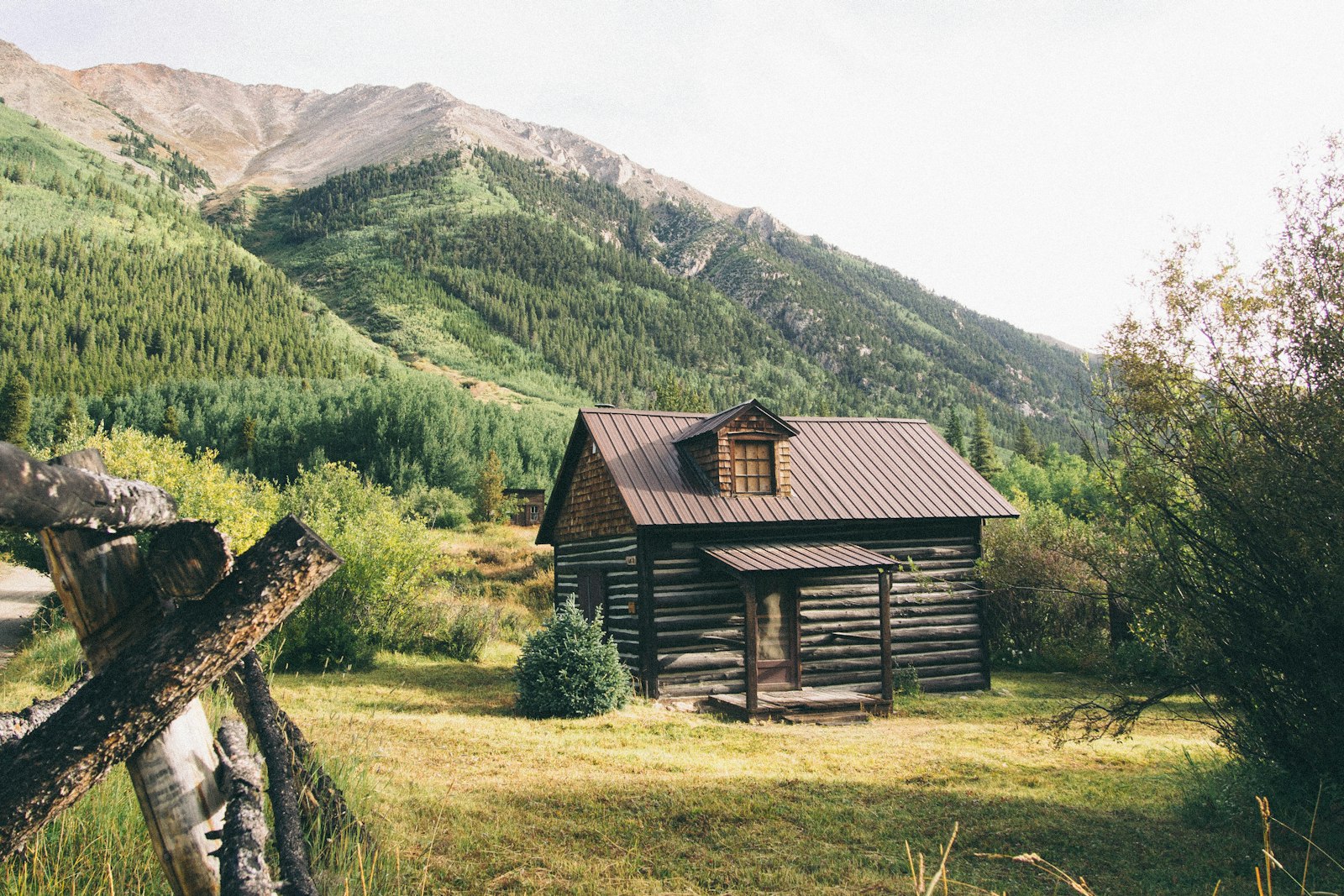 Casa in legno vicino alle montagne in una giornata di sole
