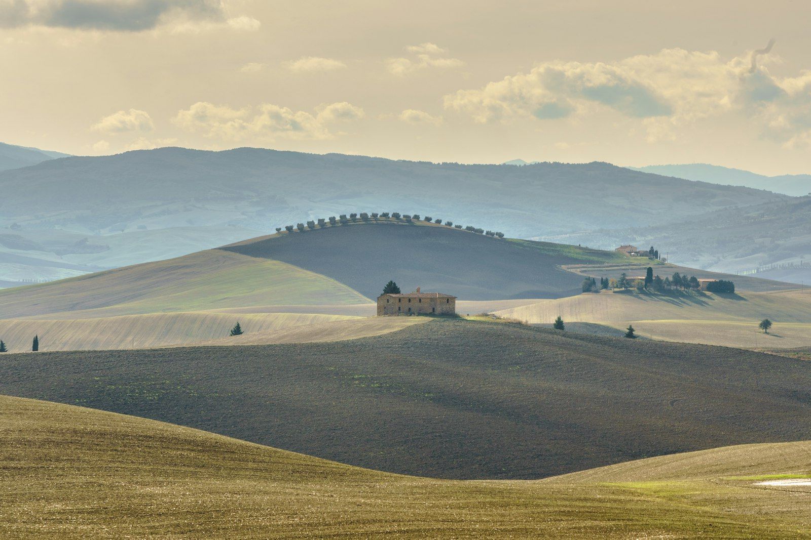 Colline coltivate della Toscana meridionale con un borgo fortificato sulla sommità